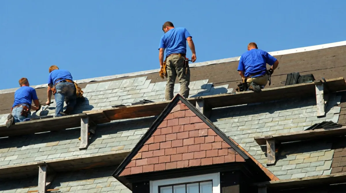 Roof replacement in progress with a team of professional contractors installing new shingles on a residential home in Evansville, IN